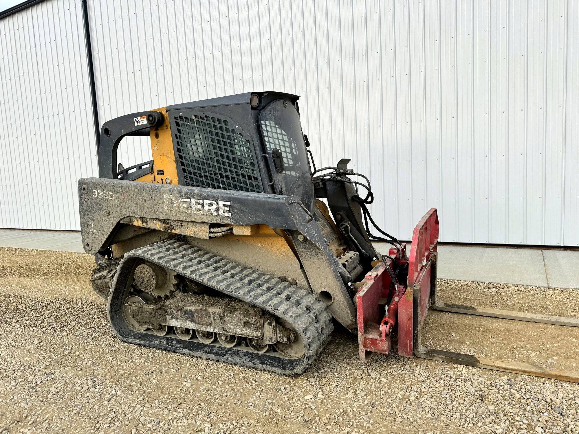 John Deere 333D compact track loader, side view, pallet forks fitted