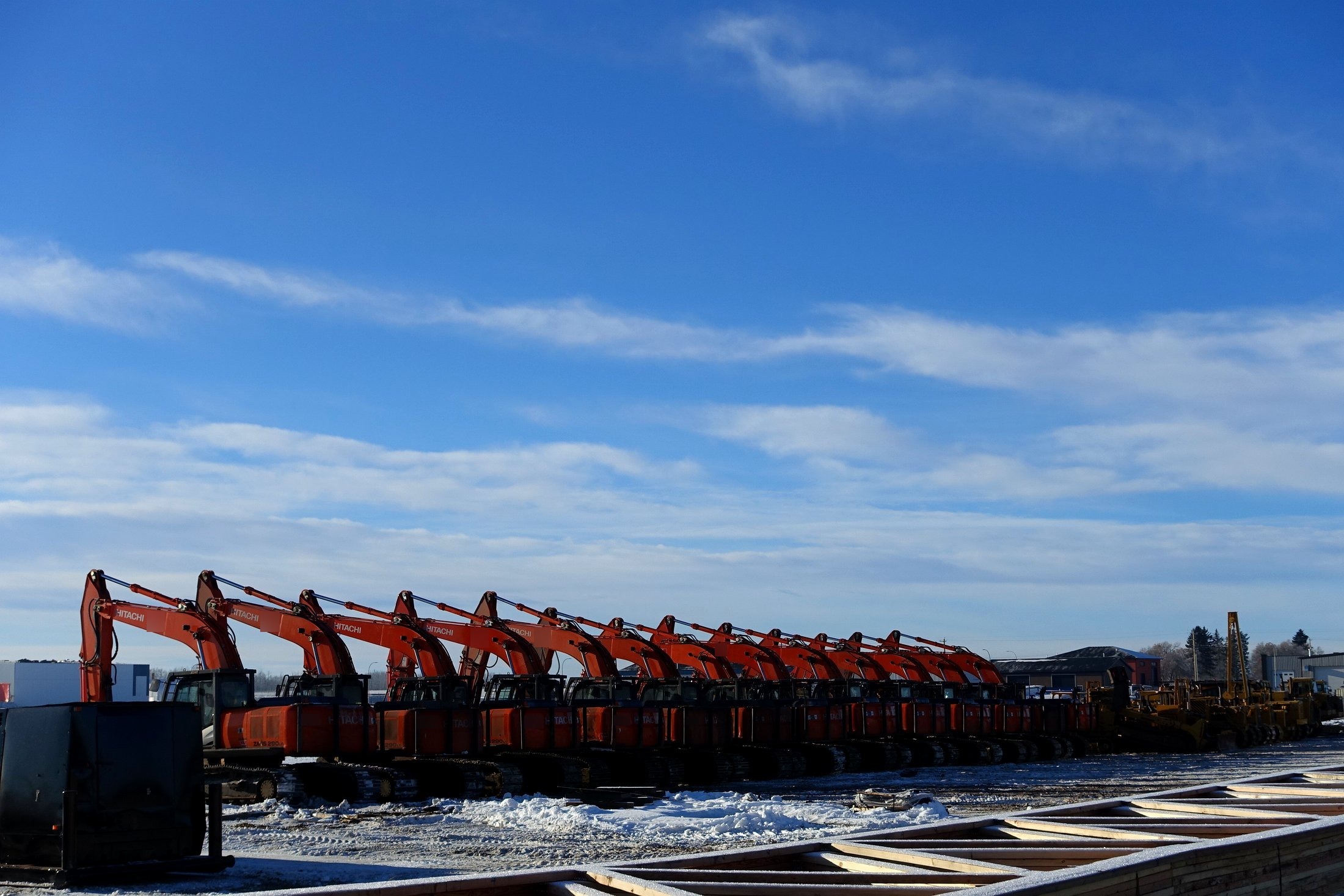 Row of Hitachi excavators parked in the equipment yard